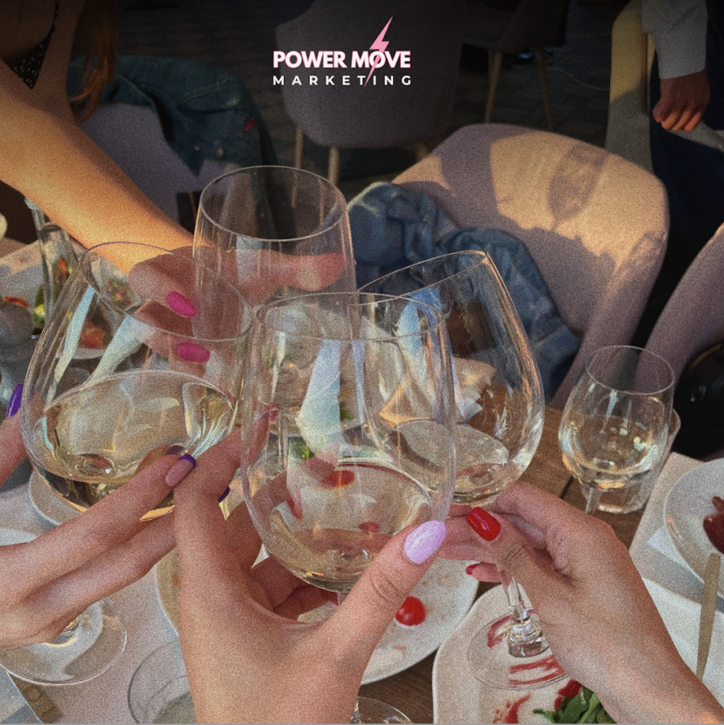 girls holding wine glasses and clinking them together